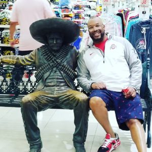 Recruiter Antwan sits with a statue in Cancun