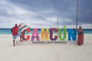 Recruiter Antwan and his wife flank a colorful Cancun sign at the Panama Jack Resorts