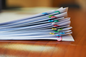 Stack of papers with multiple paperclips in varying colors
