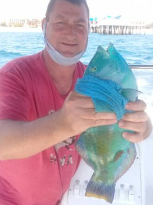 Jason caught this Tropical reef fish not far from the wooden pier behind him